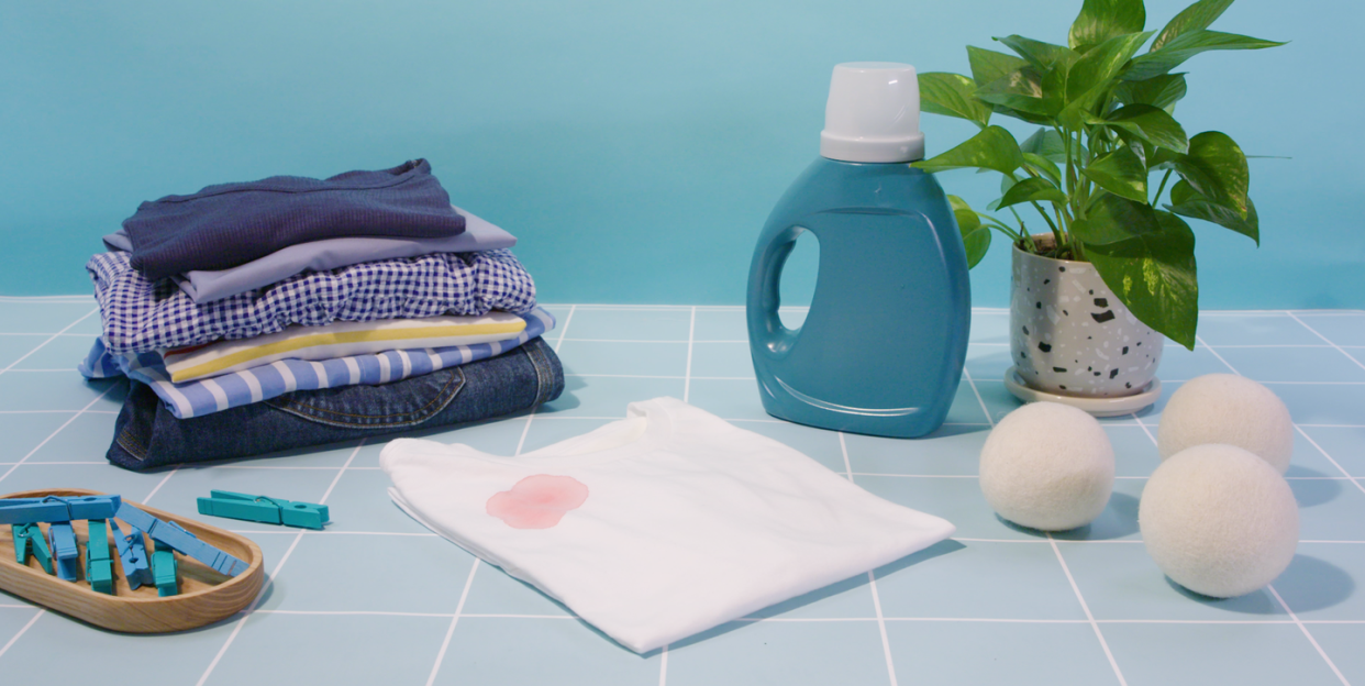 white shirt with blood stain with laundry detergent and dryer balls and clothespins