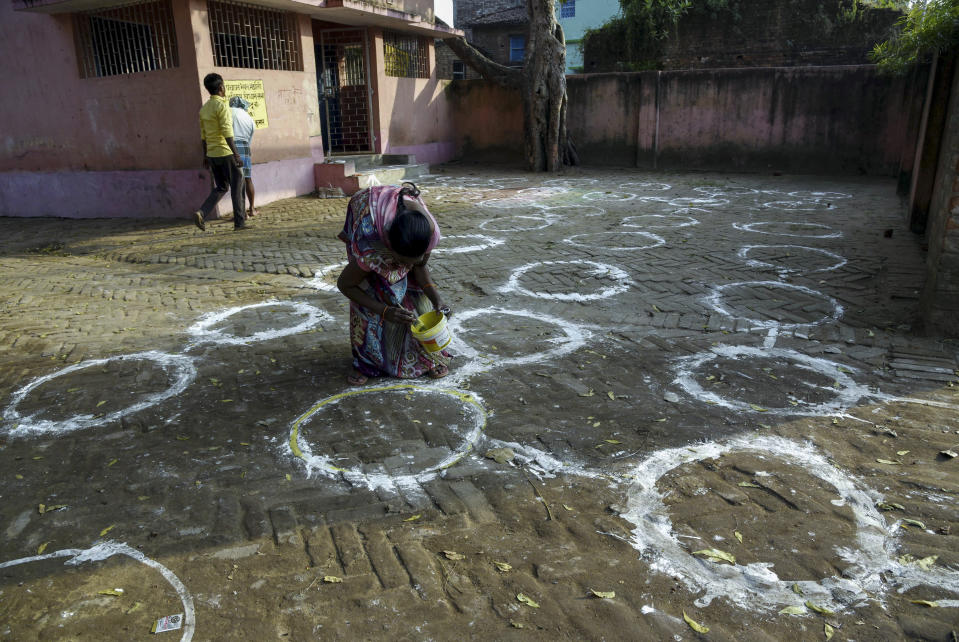 An Indian worker makes markings for voters to ensure social distancing at a polling canter on the eve of the first phase of Bihar state Assembly elections in Patna, India, Tuesday, Oct.27, 2020. Bihar is India’s third largest state with a population of about 122 million people. India’s overall total of cases for the coronavirus pandemic is nearing 8 million, trailing only the United States, which has over 8.7 million. (AP Photo/Aftab Alam Siddiqui)