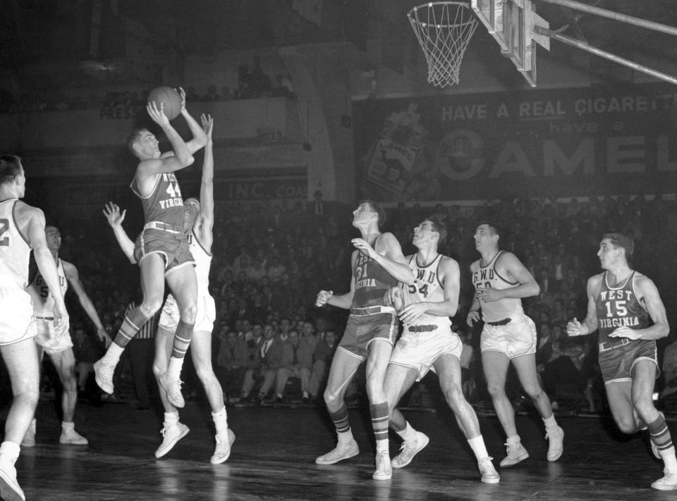 FILE - Jerry West (44) of West Virgina University shoots a jump shot against George Washington University during a Southern Conference game in Washington, March 1, 1958. Others pictured include West Virginia's Lloyd Sharrar (31) and George Washington University's Gene Guarilia (54) and Howard McDonald (50). Jerry West, who was selected to the Basketball Hall of Fame three times in a storied career as a player and executive and whose silhouette is considered to be the basis of the NBA logo, died Wednesday morning, June 12, 2024, the Los Angeles Clippers announced. He was 86.(AP Photo/Harvey Georges, File)