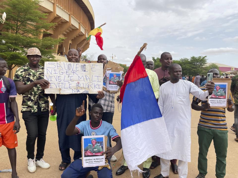 Supporters of Niger's ruling junta hold a Russian flag in Niamey, Niger, Sunday, Aug. 6, 2023. Nigeriens are bracing for a possible military intervention as time's run out for its new junta leaders to reinstate the country's ousted president. (AP Photo/Sam Mednick)