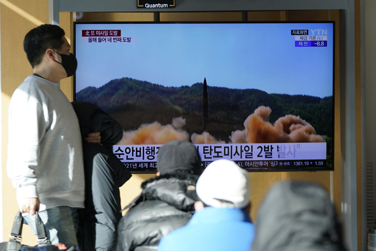 People watch a TV screen showing a news program reporting about North Korea's missile launch with a file footage at a train station in Seoul, South Korea, Monday, Jan. 17, 2022. (AP Photo/Lee Jin-man)
