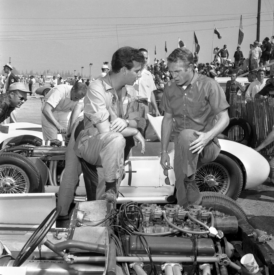 Steve McQueen, CBS television star of the western series, Wanted Dead or Alive. McQueen is also a racing enthusiast, and visits The Los Angeles Examiner Grand Prix on March 8, 1959. Pomona, CA Fairgrounds. Pictured Left to right, Bruce Kessler (race car driver) talks with Steve McQueen. Later same day, Kessler is seriously injured in a crash while driving a Sadler.