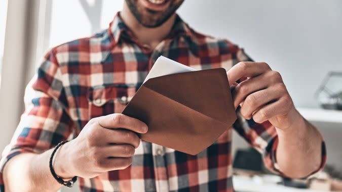 man opening up wedding invitation