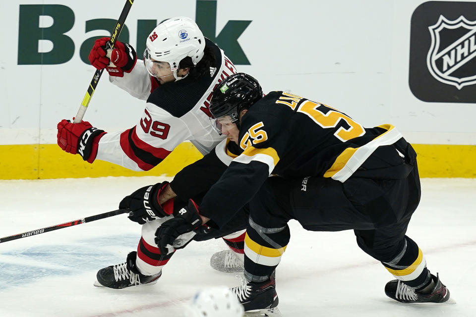 New Jersey Devils right wing Nicholas Merkley (39) and Boston Bruins defenseman Jeremy Lauzon (55) skate for position in the first period of an NHL hockey game, Thursday, Feb. 18, 2021, in Boston. (AP Photo/Elise Amendola)