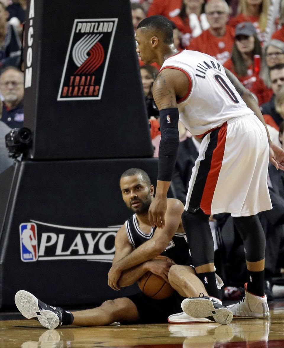 San Antonio Spurs' Tony Parker, left, calls a time out as Portland Trail Blazers' Damian Lillard (0) looks on in the second quarter of Game 3 of a Western Conference semifinal NBA basketball playoff series Saturday, May 10, 2014, in Portland, Ore. (AP Photo/Rick Bowmer)