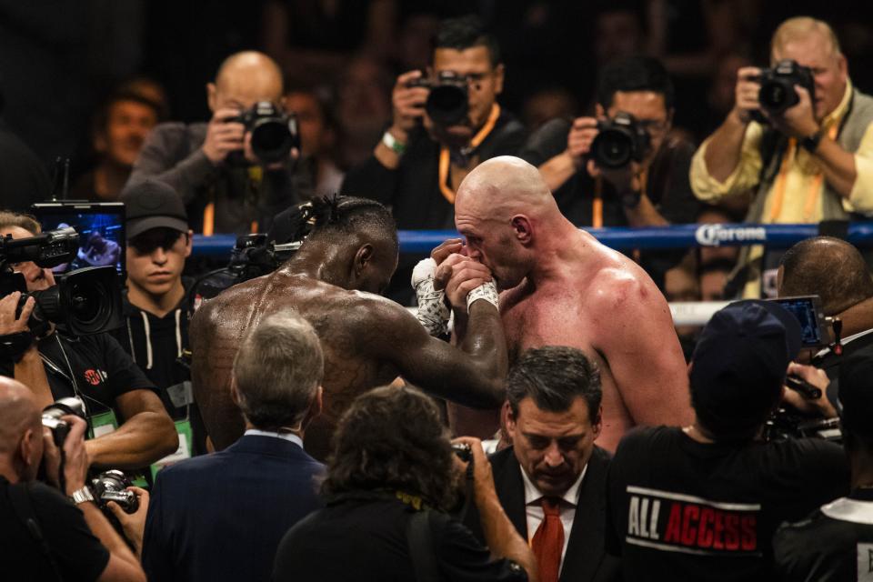 LOS ANGELES, USA - DECEMBER 01: Tyson Fury kisses Deontay Wilder on his hand at the end of WBC Heavyweight Championship at the Staples Center in Los Angeles, California on December 01, 2018.  (Photo by Philip Pacheco/Anadolu Agency/Getty Images)