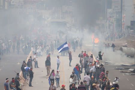 Supporters of Salvador Nasralla, presidential candidate for the Opposition Alliance Against the Dictatorship, clash with riot police as they wait for official presidential election results in Tegucigalpa, Honduras, November 30, 2017. REUTERS/Edgard Garrido