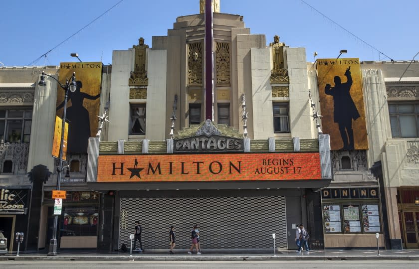 HOLLYWOOD, CA - JULY 01, 2021: Pedestrians walk past the Pantages Theatre, on Hollywood Blvd. in Hollywood, where the play, Hamilton, is scheduled to resume on August 17, 2021. Hollywood, the neighborhood, is attempting to recover from pandemic-related business closures and damage caused last year by rioters among demonstrators protesting the murder of George Floyd. (Mel Melcon / Los Angeles Times)
