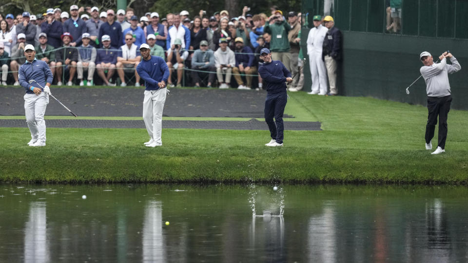 Si Woo Kim, of South Korea, Tiger Woods, Rory McIlroy, of Northern Ireland, and Fred Couples, from left, try bouncing their balls on a pond at the 16th hole during a practice for the Masters golf tournament at Augusta National Golf Club, Monday, April 3, 2023, in Augusta, Ga. (AP Photo/Mark Baker)