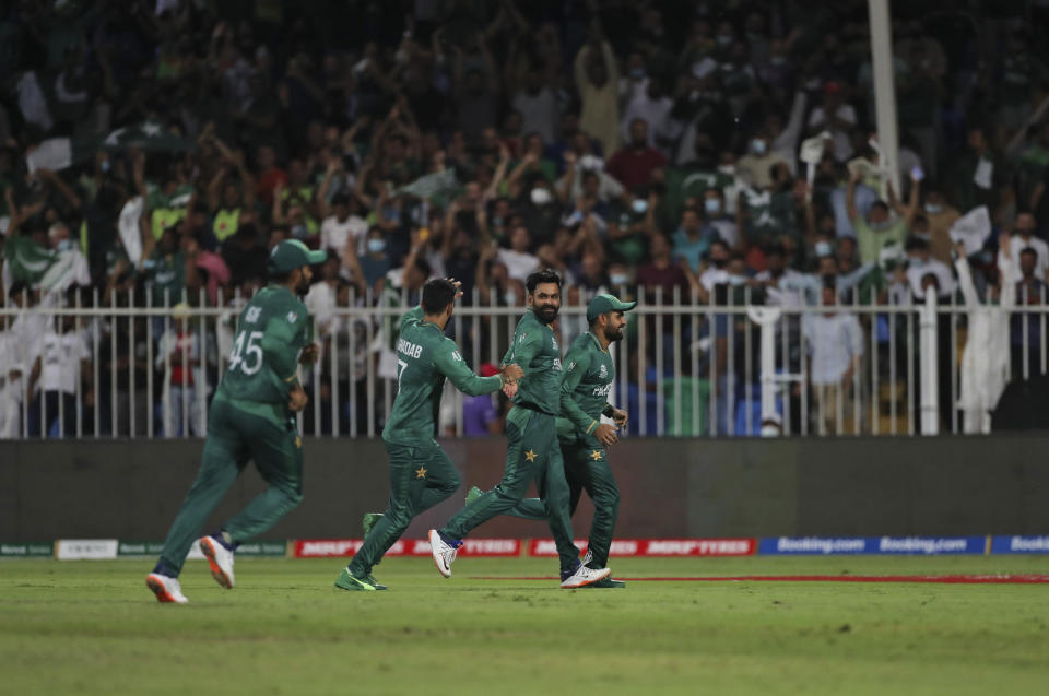 Pakistan's Mohammad Hafeez, second right, celebrates the dismissal of New Zealand's Jimmy Neesham during the Cricket Twenty20 World Cup match between New Zealand and Pakistan in Sharjah, UAE, Tuesday, Oct. 26, 2021. (AP Photo/Aijaz Rahi)