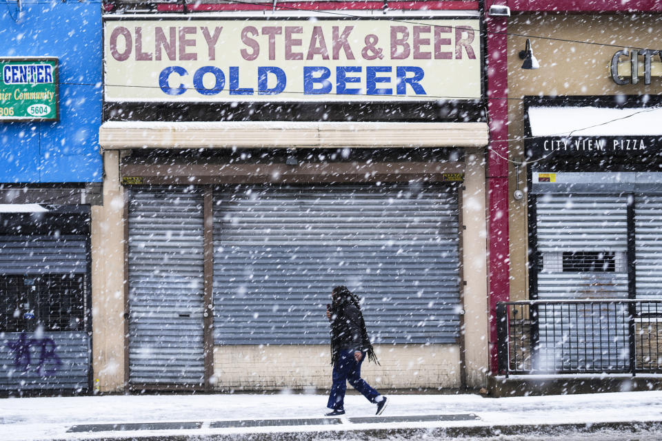 A person walks during a winter snow storm in Philadelphia, Tuesday, Feb. 13, 2024. Parts of the Northeast were hit Tuesday by a snowstorm that canceled flights and schools and prompted warnings for people to stay off the roads, while some areas that anticipated heavy snow were getting less than that as the weather pattern changed. (AP Photo/Matt Rourke)