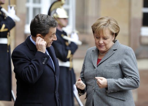 French President Nicolas Sarkozy (L) welcomes German Chancellor Angela Merkel for a european mini-summit with Italian Prime minister Mario Monti on the debt crisis, on November 24, 2011 in Strasbourg, eastern France. AFP PHOTO ERIC FEFERBERG