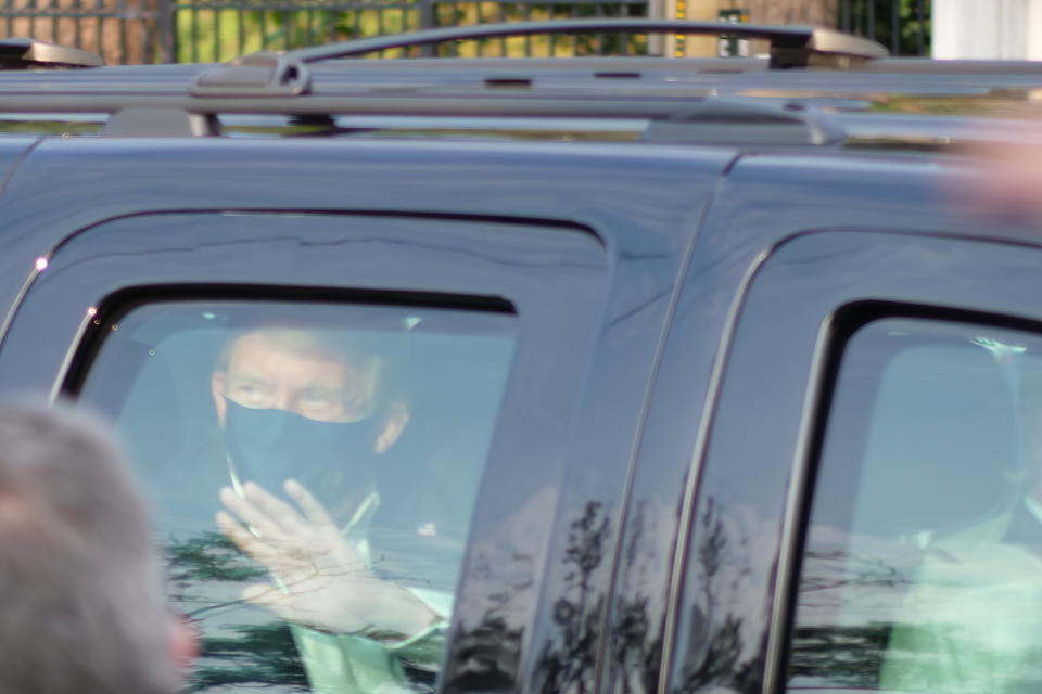 President Donald Trump waves to supporters gathered outside Walter Reed National Military Medical Center in Bethesda, Maryland, on Sunday. At least two other people were in the vehicle with him.  (Photo: ASSOCIATED PRESS)