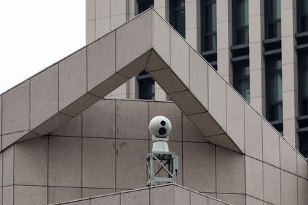 A surveillance camera is seen on the Chinese People's Liberation Army Forces building in Hong Kong December 10, 2014. REUTERS/Tyrone Siu