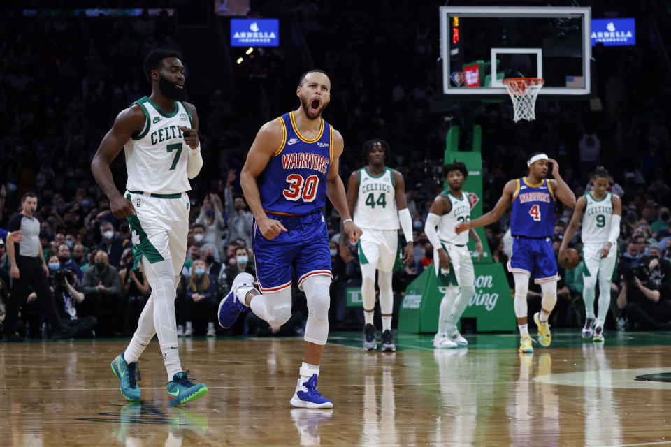 Golden State Warriors guard Stephen Curry (30) reacts after hitting a three point shot as Boston Celtics guard Jaylen Brown (7) looks on during the first half of an NBA basketball game, Friday, Dec. 17, 2021, in Boston. (AP Photo/Mary Schwalm)