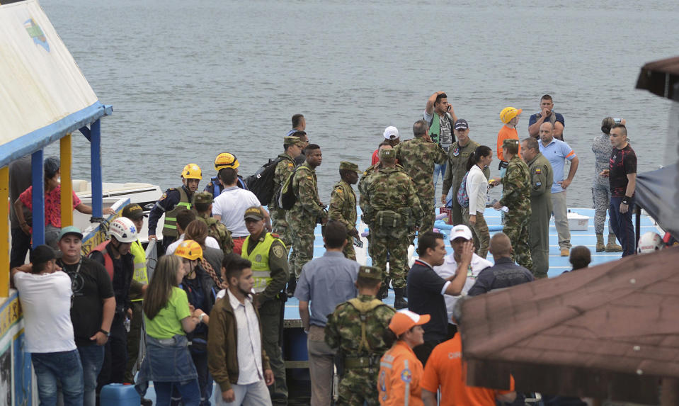 <p>Soldiers and rescue workers stand at the dock of the reservoir where a ferry sank, during search efforts in Guatape, Colombia, Sunday, June 25, 2017. (Luis Benavides/AP) </p>