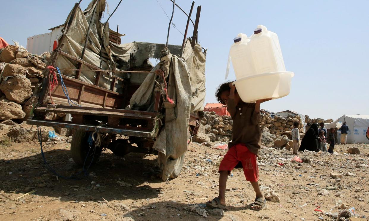 <span>A displaced Yemeni child carries water containers donated by Unicef at a camp on the outskirts of Sana'a last year.</span><span>Photograph: Yahya Arhab/EPA</span>