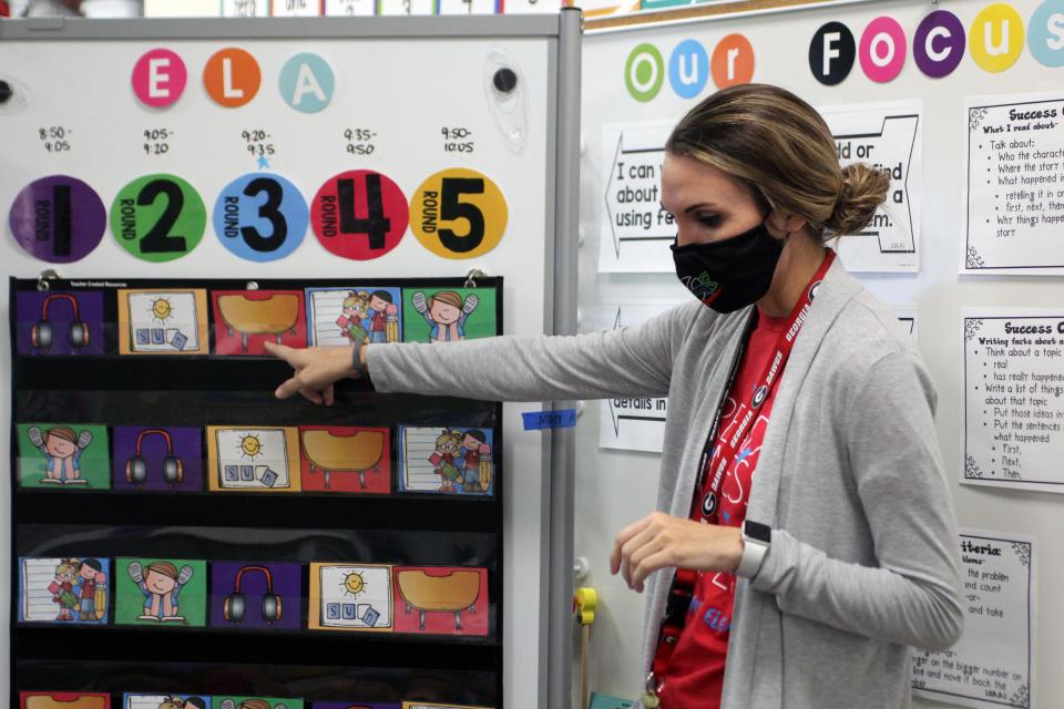 Heather Miller explains literacy centers to her students. Each day, Miller spends two hours with small groups of students to teach critical math and reading skills.