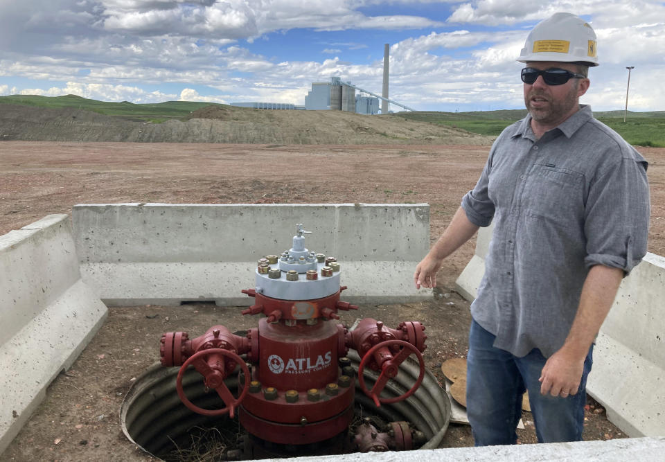 Fred McLaughlin, director of the Center for Economic Geology Research at the University of Wyoming, stands near one of two wells drilled near the Dry Fork Station coal-fired power plant outside Gillette, Wyo., on June 14, 2022. McLaughlin and other researchers are studying whether formations as deep as 10,000 feet can be used to store the power plant’s carbon dioxide emissions. (AP Photo/Mead Gruver)