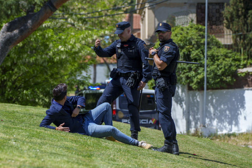 Police officers block a man as the hearse carrying the coffin with the remains of the Jose Antonio Primo de Rivera, founder of the Spanish fascist party, the Falange, drives to San Isidro Cemetery in Madrid, Spain, Monday, April 24, 2023. The body of Jose Antonio Primo de Rivera is exhumed from a Madrid mausoleum and transferred to a city cemetery. (AP Photo/Manu Fernandez)