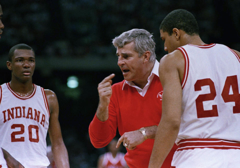 FILE - Indiana coach Bob Knight gestures while instructing players, including Rick Calloway (20) and Daryl Thomas (24), during a win over UNLV in an NCAA men's college basketball tournament semifinal March 30, 1987, in New Orleans. Knight, the brilliant and combustible coach who won three NCAA titles at Indiana and for years was the scowling face of college basketball, has died. He was 83. Knight's family made the announcement on social media on Wednesday night, Nov. 1, 2023, saying he was surrounded by family members at his home in Bloomington, Ind. (AP Photo/Bob Jordan, File)