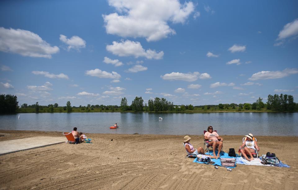 "It's packed on the weekends so we like to come during the middle of the week," Kari Bailey, of St. Johns (pictured on the left watching her boys swim) says about Motz County Park in Clinton County as a trio of beachgoers relax in the sun Wednesday, June 14, 2023.