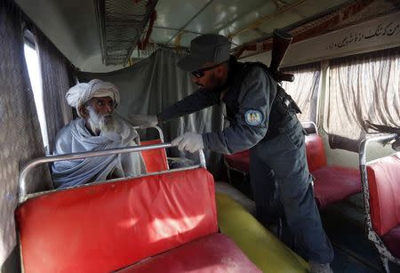 A policeman inspects a passenger at a checkpoint on the outskirts of Farah province February 4, 2015. REUTERS/Omar Sobhani