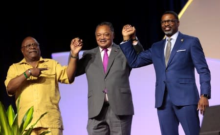 Reverend Wendell Anthony, civil rights activist Jesse Jackson and NAACP President Derrick Johnson acknowledge the attendees during the U.S. Presidential candidate forum at the annual convention of the National Association of the Advancement for Colored Peo