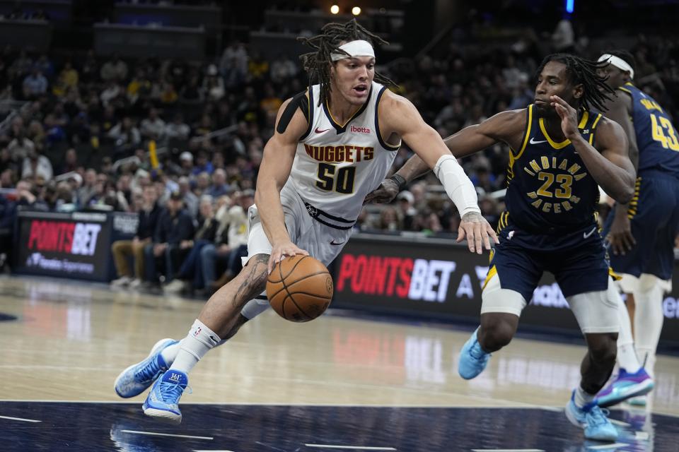 Denver Nuggets' Aaron Gordon (50) goes to the basket against Indiana Pacers' Aaron Nesmith (23) during the first half of an NBA basketball game, Tuesday, Jan. 23, 2024, in Indianapolis. (AP Photo/Darron Cummings)