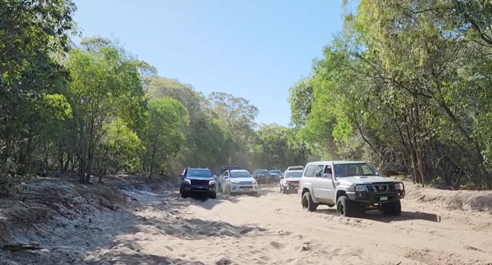 Cars driving on the sandy beach access road on Bribie Island. 
