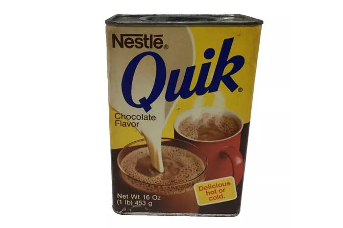 Nestlé Quik chocolate flavor tin with an image of milk being poured into a cup of hot chocolate. The tin reads "Delicious hot or cold." Net weight: 16 oz (1 lb) 453 g