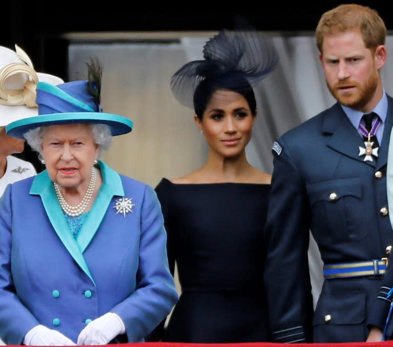 El príncipe Enrique (d), su esposa Meghan Markle (c) y la reina de Inglaterra Isabel II, en el palacio de Buckingham en Londres, el 10 de julio de 2018