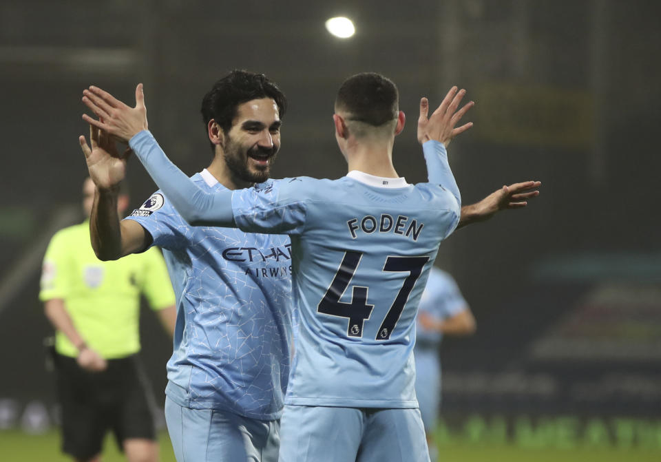 Manchester City's Ilkay Gundogan, left, celebrates with Manchester City's Phil Foden after scoring his side's third goal during the English Premier League soccer match between West Bromwich Albion and Manchester City at the Hawthorns stadium in West Bromwich, England, Tuesday, Jan. 26, 2021. (Nick Potts/Pool via AP)