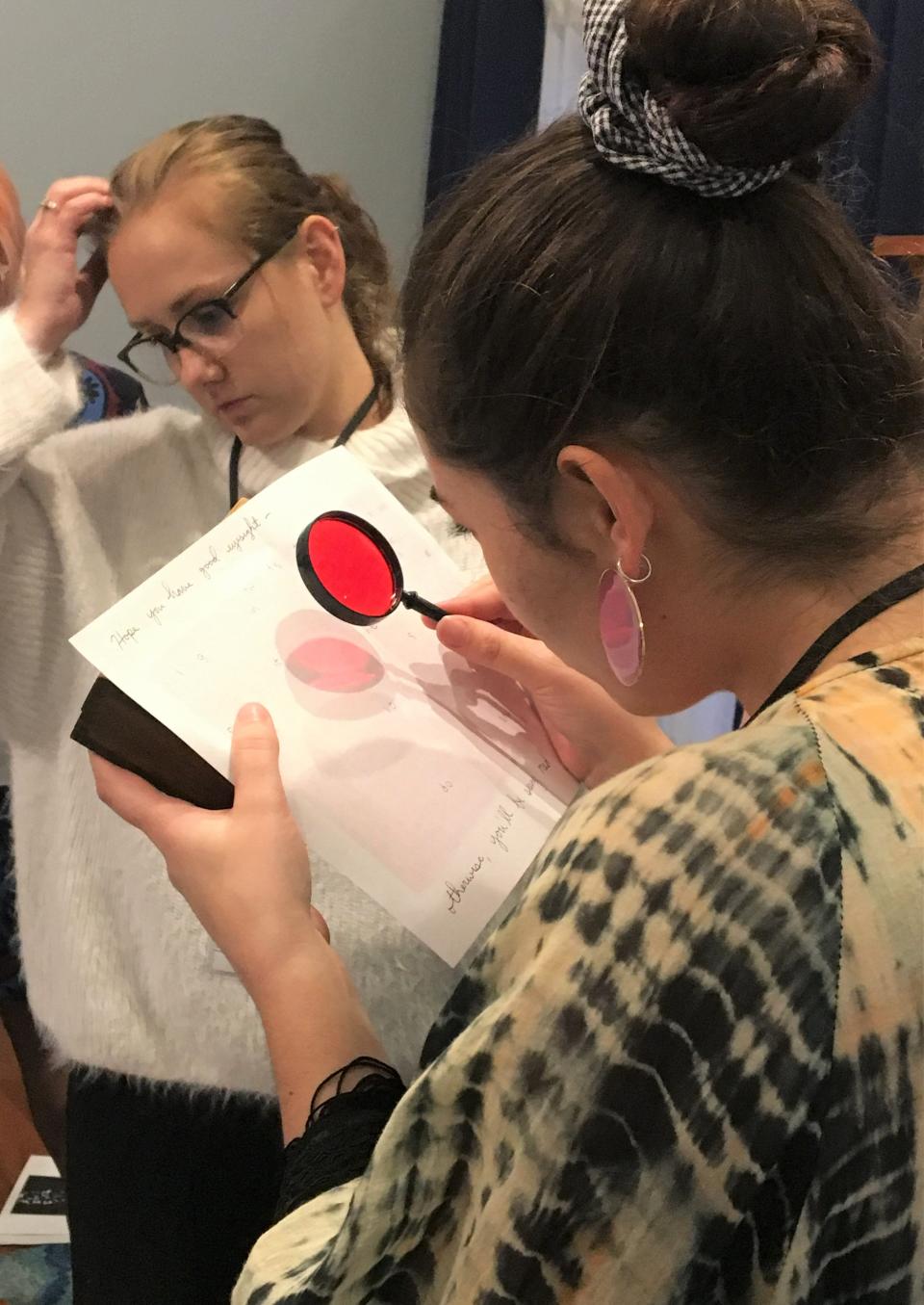 Kate Colvin, foreground, works on solving a puzzle during an escape room event.