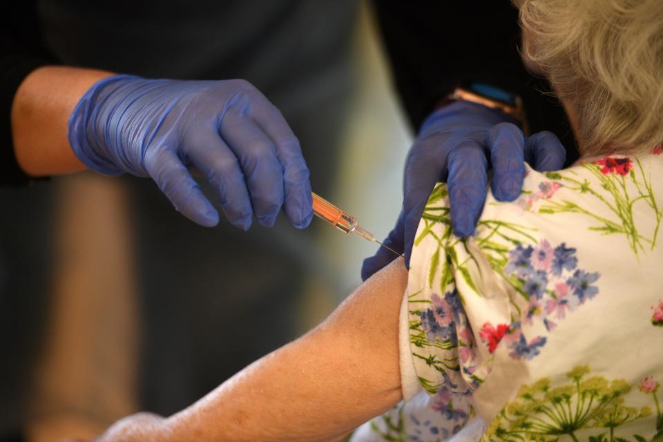 A resident receives a dose of the Oxford-AstraZeneca Covid-19 vaccine at the Belong Wigan care home in Wigan, northwest England, on January 21, 2021. - Some British hospitals resemble a "war zone" due to the influx of coronavirus patients in the country's latest wave of the disease, the government's chief scientific adviser said Wednesday. (Photo by Oli SCARFF / AFP) (Photo by OLI SCARFF/AFP via Getty Images)