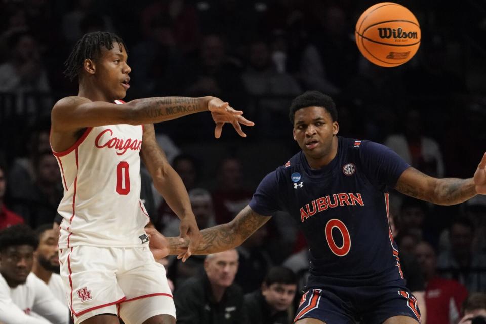 Houston guard Marcus Sasser, left, passes the ball in front of Auburn guard K.D. Johnson.