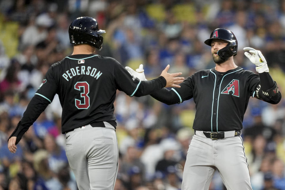 Arizona Diamondbacks' Christian Walker celebrates hitting a two-run home run with designated hitter Joc Pederson, who also scored, during the fourth inning of a baseball game against the Los Angeles Dodgers, Tuesday, July 2, 2024, in Los Angeles. (AP Photo/Ryan Sun)