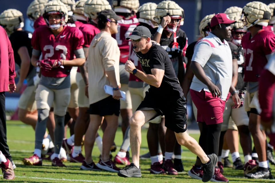 Florida State head coach Mike Norvell runs on the field as the team prepares for the Orange Bowl NCAA college football game, Wednesday, Dec. 27, 2023, in Davie, Fla. Florida State is scheduled to play Georgia in the Orange Bowl Saturday at Hard Rock Stadium in Miami Gardens. (AP Photo/Lynne Sladky)