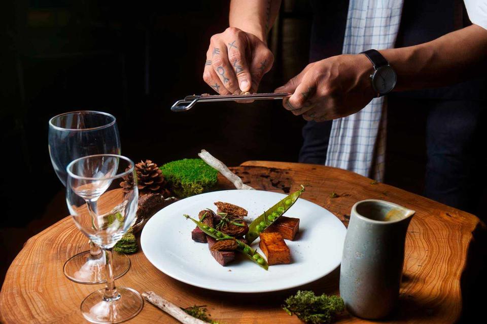 Courtesy of  Quark Expeditions An Intuit chef finishes a plated dish of caribou, peas, and mushrooms aboard the Ultramarine. 