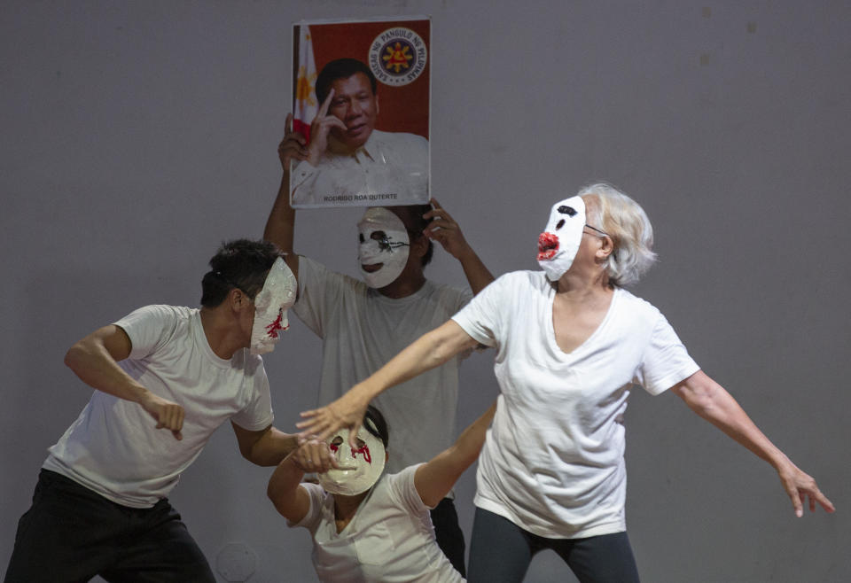 FILE - In this Wednesday, March 4, 2020 file photo, relatives of people killed during the government's "war on drugs" campaign perform on stage in front of a picture of Philippine President Rodrigo Duterte at a school in metropolitan Manila, Philippines. International Criminal Court judges on Wednesday Sept. 15, 2021, authorized an investigation into the Philippines' deadly "war on drugs" campaign, saying the crackdown "cannot be seen as a legitimate law enforcement operation." (AP Photo/Aaron Favila, File)