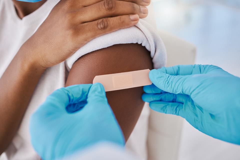 Plaster bandage on arm for covid vaccine, injection and cure given to patient by a doctor in a hospital. Closeup of flu jab, antiviral shot and health treatment to boost immunity and prevent illness.