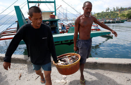 Fishermen, who has just returned from fishing in disputed Scarborough shoal, unload fish from a boat in Subic, Zambales in the Philippines, November 1, 2016. REUTERS/Erik De Castro