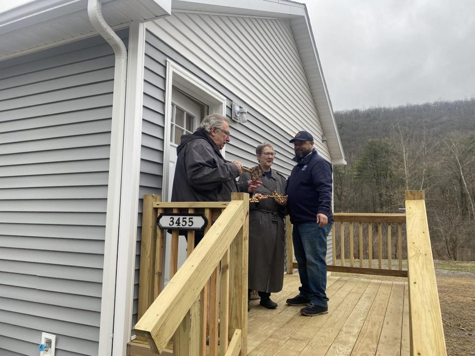 Faith Southard and Bill Dugan receive keys to their new duplex home from Steuben County Habitat for Humanity Executive Director Steve Daniels during a dedication at Hornby Road, in the Town of Corning