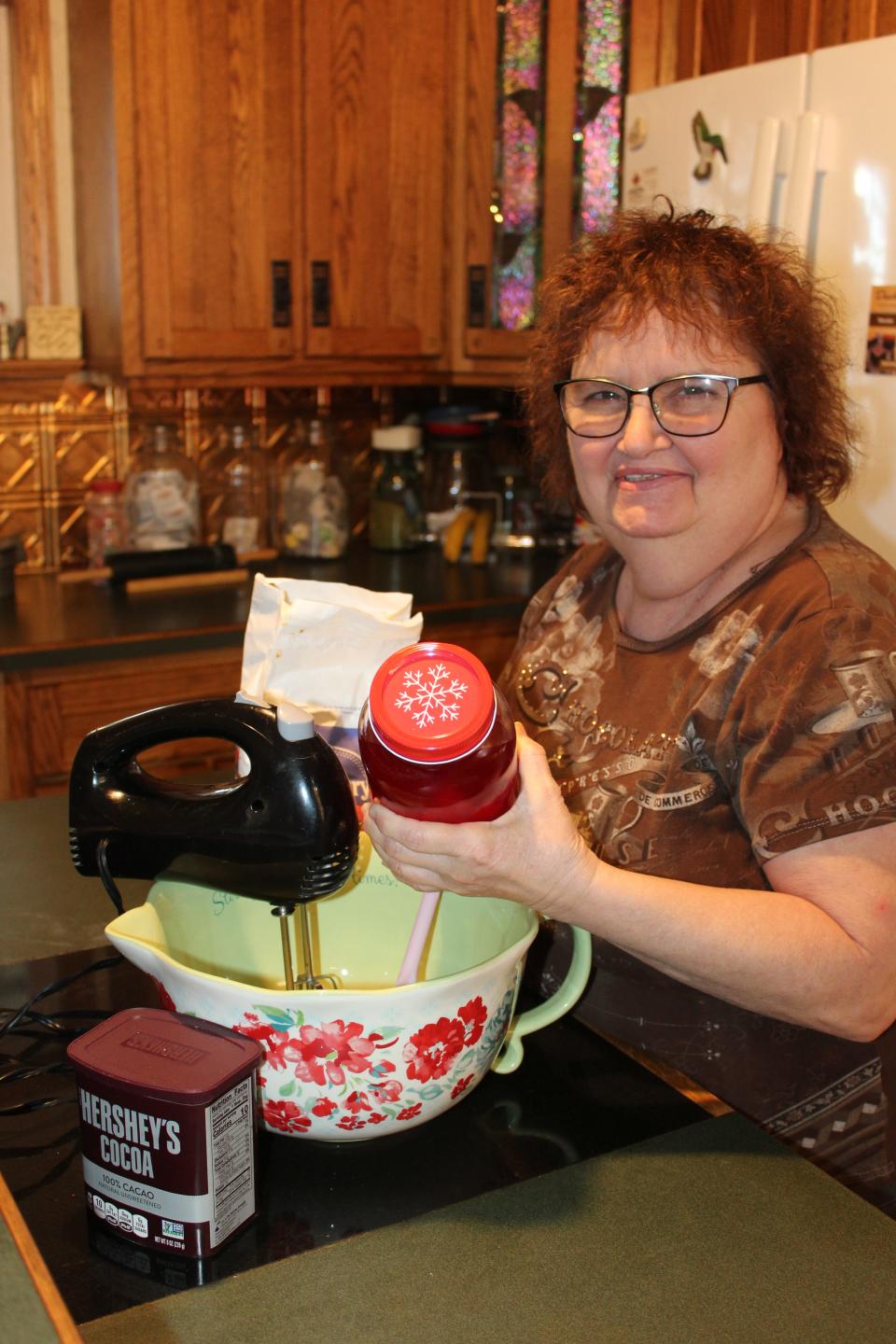 Patty Bittner of Meyersdale holds a jar of cherries soaking in brandy while making some preparations in her kitchen for the upcoming Death By Chocolate fundraiser for the Meyersdale Public Library at 5:30 p.m. Friday at Amity United Church of Christ in Meyersdale. Bittner has made chocolate-covered brandy cherries for every Death By Chocolate event for over 20 years and has become famous for it.