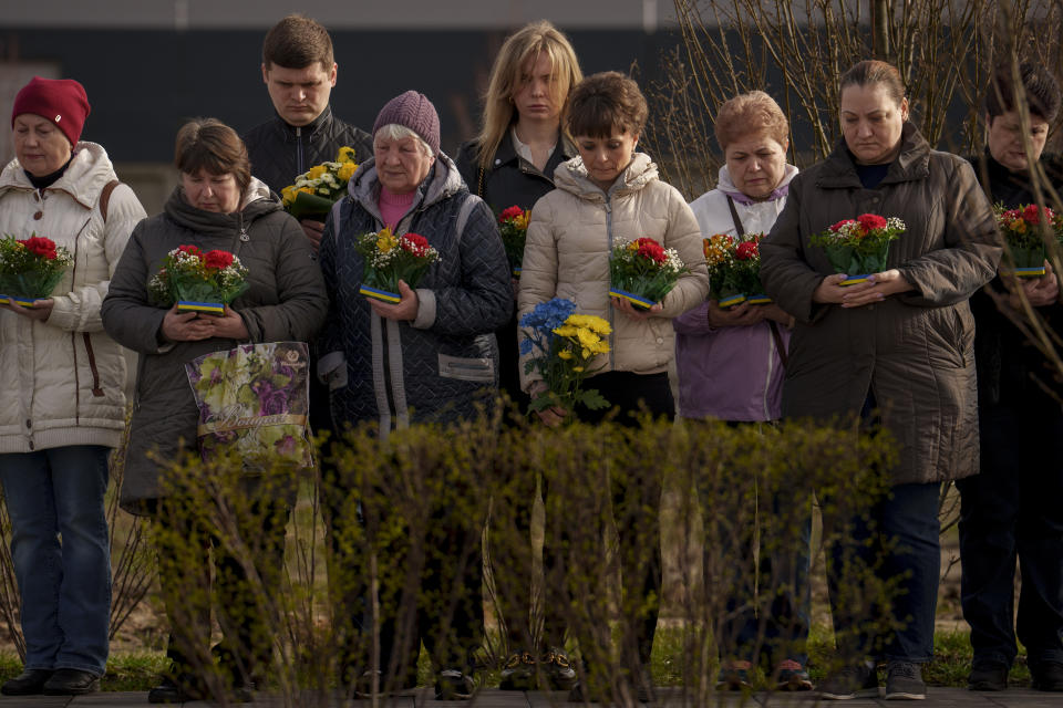 Relatives of those killed during the Russian occupation attend a commemoration of the victims at a cemetery in Bucha, Ukraine, Sunday, March 31, 2024. Ukrainians mark the second anniversary of the liberation of Bucha, during which Russian occupation left hundreds of civilians dead in the streets and in mass graves in Bucha during the initial months of the Russian invasion in 2022. (AP Photo/Vadim Ghirda)