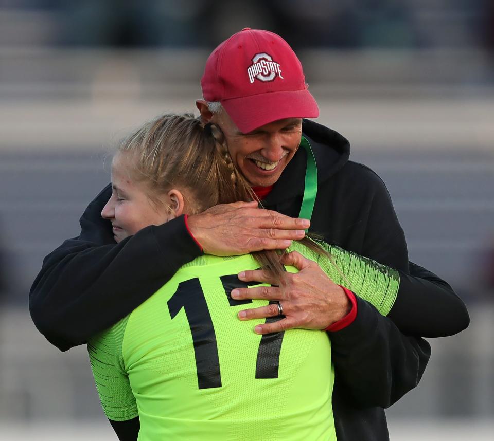 Manchester girls soccer coach Eddie Kissner hugs senior goalkeeper Madi Cox after beating Champion in a regional final Saturday in Tallmadge.