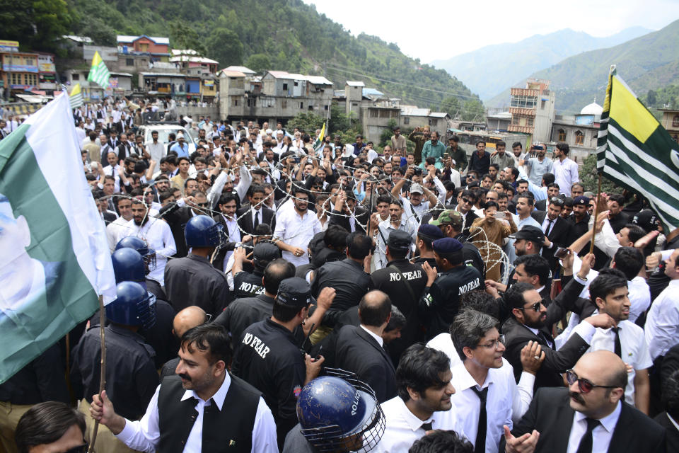 Pakistani police officers try to stop protesters from reaching the Line of Control between Pakistan and Indian Kashmir, at the border town of Chakoti, in Pakistani Kashmir, Thursday, Aug. 29, 2019. Kashmir is divided between India and Pakistan since they won independence from British colonialists in 1947. They have fought two wars over its control. (AP Photo/M.D. Mughal)