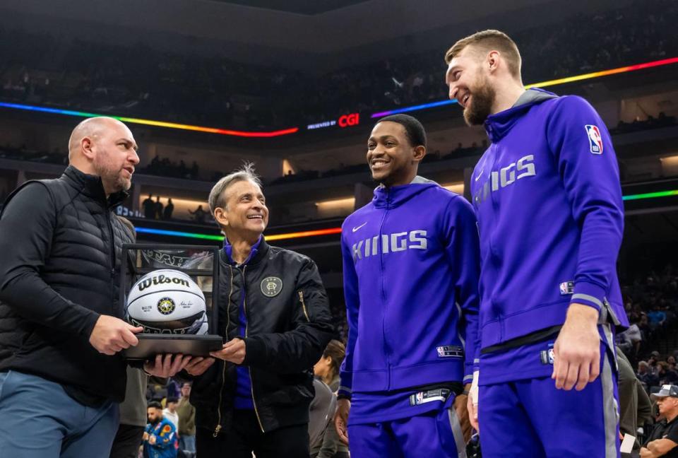 Sacramento Kings guard De’Aaron Fox (5) and center Domantas Sabonis (10), right, are presented with an All-Star ball by team owner Vivek Ranadivé and general manager Monte McNair, left, before the Kings’ overtime NBA basketball win against the Dallas Mavericks on Saturday, Feb. 11, 2023, at Golden 1 Center in Sacramento.