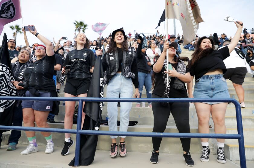 Angel City FC supporters cheer in the stand at a game