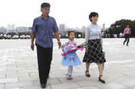 A child and her parents visit the statues of President Kim Il Sung and Chairman Kim Jong Il on Mansu Hill to commemorate the 77th anniversary of Korea's Liberation in Pyongyang, North Korea, Monday, Aug. 15, 2022. (AP Photo/Cha Song Ho)